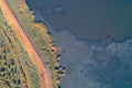 Industrial pollution abstract. Aerial view of sharp boundaries between red dirt road, vegetation, and sludge pond. Royalty Free Stock Photo