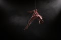 Aerial acrobat in the air ring. Young woman performs the acrobatic elements in the air hoop. Aerialist in on black Royalty Free Stock Photo