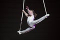 Aerial acrobat performs a circus trick.