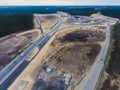 Aerial air view of a massive construction site with a heavy vehicle, bulldozer and excavator, building a new road, working and unl