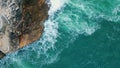 Aerial amazing rocky coast washed sea water with foam. Waves crashing on cliff. Royalty Free Stock Photo