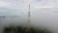 Aerial ascending telco tower in the foggy