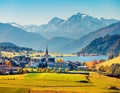 Aerial autumn view of San Valentin village. Colorful morning scene of small Italian village located on shore of Muta lake, South