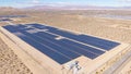 AERIAL: Barren landscape surrounds a large farm of solar panels in California. Royalty Free Stock Photo