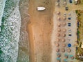 Aerial of a beach with a boat and straw umbrellas in Cape of Rodon, Albania