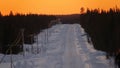 AERIAL: Beautiful orange sunset gently illuminating the dense forest and highway Royalty Free Stock Photo