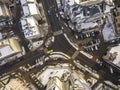 Aerial black and white winter top view of modern city with tall buildings, parked and moving cars along streets with road marking Royalty Free Stock Photo