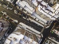 Aerial black and white winter top view of modern city with tall buildings, parked and moving cars along streets with road marking Royalty Free Stock Photo