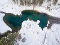 Aerial of a blue and green lake with snow in winter in the Altai mountains in Russia. Nature and scenic spots