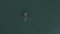 Aerial Boat on the lake. Aerial view on two men in a boat on a lake, rowed to the shore. Lonely boat in the middle of