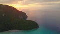 AERIAL: Breathtaking golden sunset illuminating boats and cliffs in Thailand.