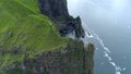 AERIAL: Breathtaking shot of photographer taking photos from the edge of a cliff