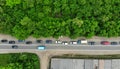 Aerial. Car traffic on the narrow asphalt road between green trees. Top view Royalty Free Stock Photo