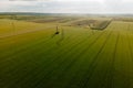 Aerial cinematic clip drone flies rising over a wheat field and High voltage electric towers.