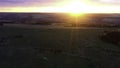 Aerial cinematic panoramic view of the farm field during sunset. Clip. Drone flies over agriculture green field. Royalty Free Stock Photo