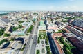 Aerial city view with crossroads and roads, houses, buildings, parks and parking lots. Sunny summer panoramic image