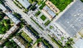Aerial city view with crossroads and roads, houses, buildings, parks and parking lots. Sunny summer panoramic image