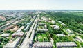 Aerial city view with crossroads and roads, houses, buildings, parks and parking lots. Sunny summer panoramic image