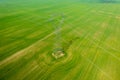 Aerial close-up view of electricity pylon with power lines over agricultural field