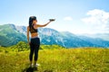 Aerial close up view pretty caucasian woman hold drone in hand for take off in scenic mountains location. Aerial cinematography