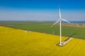 Aerial close up view to wind turbine and power station between yellow and green fields Royalty Free Stock Photo