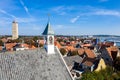 Aerial close up of Westerkerk church bell tower with rooster weather vane in West-Terschelling, Netherlands. Brandaris lighthouse.