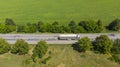 Aerial. Commercial truck driving by the roadway along the agricultural field