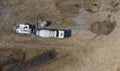 Aerial. Concrete mixer truck delivers concrete through a long hose. Top view