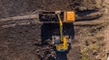 Aerial construction - top down view of an excavator and truck working on a construction site