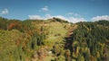 Aerial cottages at mountain forest. Autumn nobody nature landscape. Houses at green grass mount hill Royalty Free Stock Photo