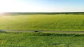 Aerial. Countryside road between two green fields. Agriculture landscape. View from drone. Royalty Free Stock Photo