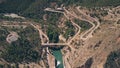 Aerial down view of windy hairpinned car road and dam in mountains in Spain