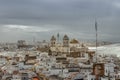 Aerial dramatic panoramic view of the old city, rooftops and Cathedral de Santa Cruz in cloudy day from tower Tavira in Cadiz, Royalty Free Stock Photo