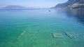 Aerial drone bird`s eye view photo of tourists snorkeling above old Sunken City of Epidauros, Greece