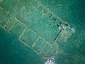 Aerial drone bird`s eye view photo of tourists snorkeling above old Sunken City of Epidauros, Greece