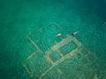 Aerial drone bird`s eye view photo of tourists snorkeling above old Sunken City of Epidauros, Greece