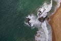 Aerial drone bird view shot of the sea shore with turquoise blue water, large white waves and foam, empty beach with yellow sand, Royalty Free Stock Photo