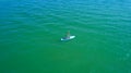 Aerial drone birds eye view of young woman exercising sup board in turquoise tropical clear waters Royalty Free Stock Photo