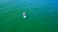 Aerial drone birds eye view of young woman exercising sup board in turquoise tropical clear waters Royalty Free Stock Photo