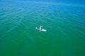 Aerial drone birds eye view of young woman exercising sup board in turquoise tropical clear waters Royalty Free Stock Photo