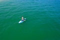 Aerial drone birds eye view of young woman exercising sup board in turquoise tropical clear waters Royalty Free Stock Photo