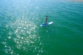 Aerial drone birds eye view of young woman exercising sup board in turquoise tropical clear waters Royalty Free Stock Photo