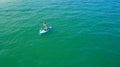 Aerial drone birds eye view of young woman exercising sup board in turquoise tropical clear waters Royalty Free Stock Photo