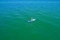 Aerial drone birds eye view of young woman exercising sup board in turquoise tropical clear waters Royalty Free Stock Photo