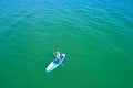 Aerial drone birds eye view of young woman exercising sup board in turquoise tropical clear waters Royalty Free Stock Photo