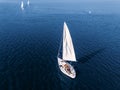 Aerial drone expensive yacht with white sail on blue water of sea Royalty Free Stock Photo