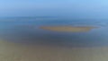 Aerial drone flying, dolly in of calm, sea shallow tideland