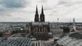 Aerial drone footage circling the Cologne Cathedral along the shore of the Rhine River in Germany.