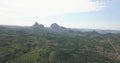 Aerial drone footage of a tropical landscape, with forest and mountains Kumbira forest reserve, small village and huge geologic