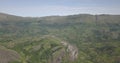 Aerial drone footage of a tropical landscape, with forest and mountains Kumbira forest reserve, small village and huge geologic